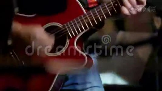 摇滚音乐会的音乐家-吉他手在夜总会演奏红色吉他，关闭视频