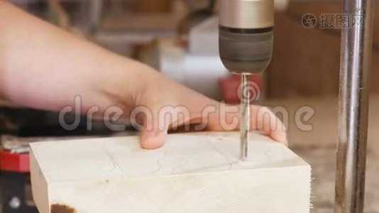 工人在木模板上钻洞。 木制玩具的制造。 特写双手。视频