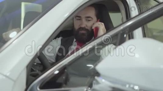 这幅画很吸引人，有自信，留着胡子的商人坐在车里，检查从车里买的新车视频