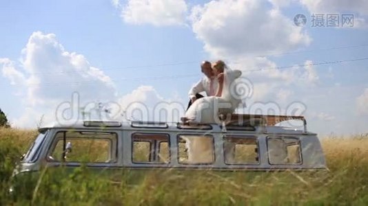 新娘和新郎在阳光明媚的夏天的公共汽车顶部。 不寻常的婚礼视频