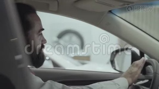 这幅画很吸引人，有自信，留着胡子的商人坐在车里，检查从车里买的新车视频