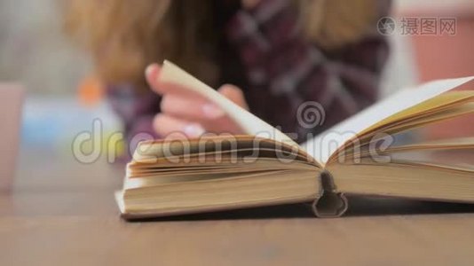 女人的手拿着一本书，在阅读教育休闲读物时，手指在书页上移动视频