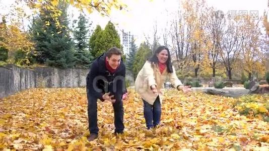 秋天，一家人带着黄叶在公园玩耍视频