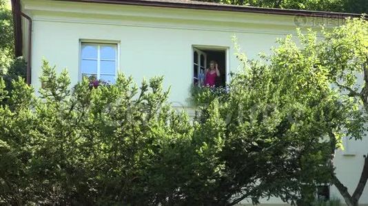 家庭主妇在夏天在自己家里用花盆浇水。 4K视频