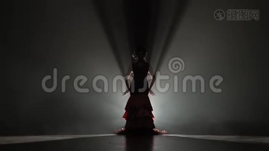 穿着漂亮裙子的女孩在跳舞。 从后面的光。 烟雾背景。 慢动作。 剪影视频