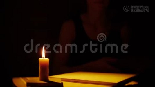 书和蜡烛。 火和烟。 女人在看书。视频