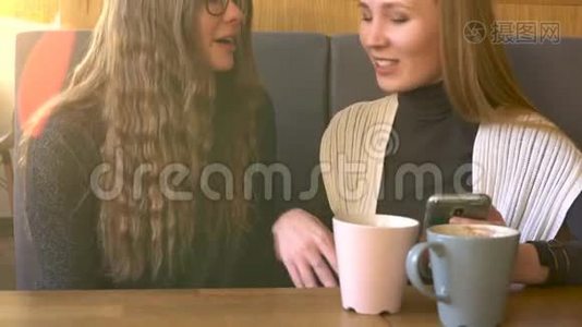 两个朋友的女人在咖啡馆里用手机交流视频