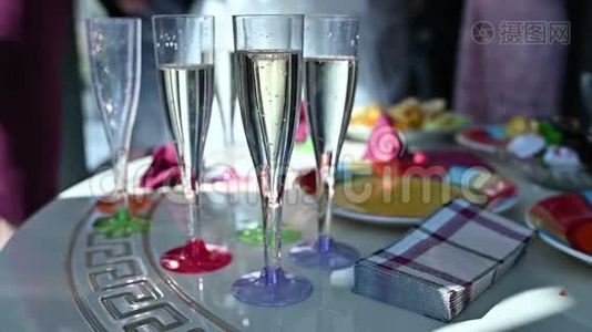 在一张桌子上排着一排排的香槟酒，等待着婚宴的客人视频