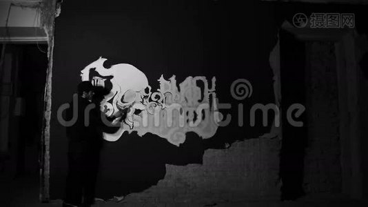 艺术家在黑色的墙上画有头骨的白色格雷菲蒂视频