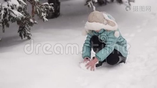 冬天公园里的小女孩雕刻雪人。 从天而降的雪。视频