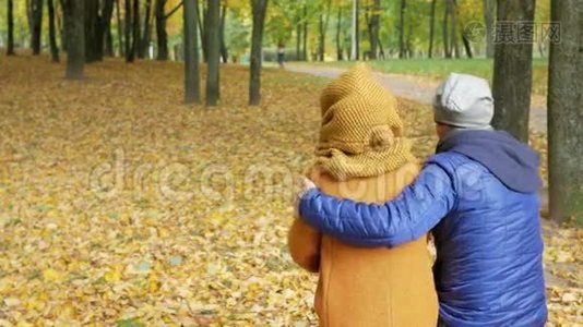 父亲和女儿在秋天的公园里休息。 爸爸和孩子微笑着看着美丽的风景视频