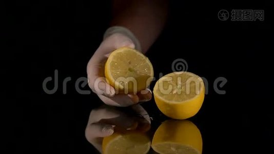 在黑暗的背景上用手捏柠檬视频