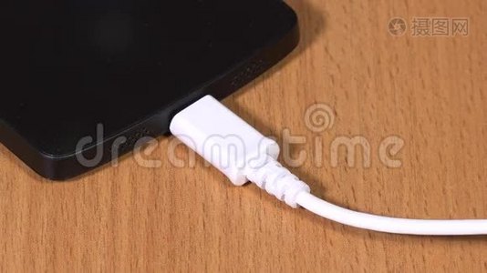 女性手拔下白色微型USB电缆至智能手机视频