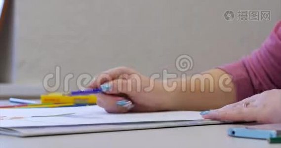 年轻的艺术家的手，女艺术家用石墨铅笔画画布，坐在桌子上画画布视频