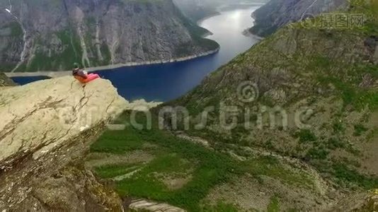 挪威。 坐在巨人边缘的男人和女孩视频