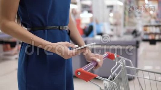 在超市购物时使用手机的女人，在购物中心购物店购物视频