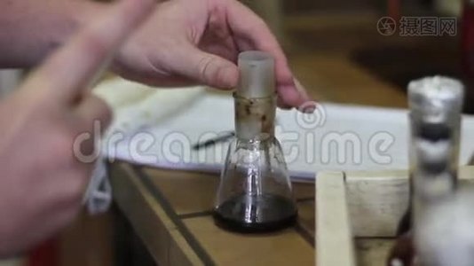 在化学实验中，用吸管和烧瓶把科学家的手合上视频