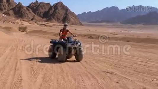 在埃及沙漠山脉背景下乘坐四驱车的女孩视频