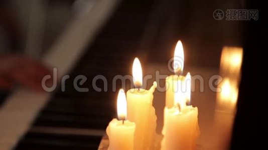 在蜡烛的灯光下，特写女性双手在黑暗中弹钢琴视频