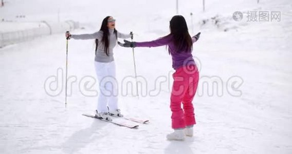 年轻女子教她的朋友滑雪视频