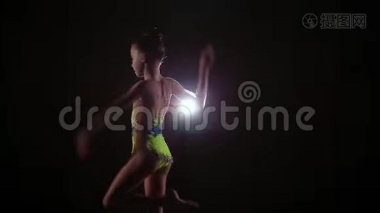 漂亮可爱的小女孩运动员穿着鲜艳的泳装表演艺术体操元素视频
