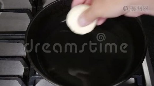 厨师把甜甜圈放进热油里炸成深脂肪。视频