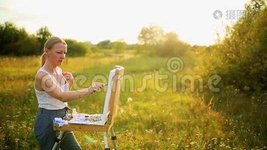 年轻的艺术家画一幅秋天的风景画视频