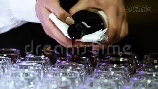 一位年轻的女酒调师的特写双手斟满红酒。视频