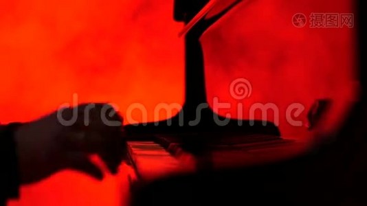一个钢琴家弹钢琴，然后关闭他，红色背景视频