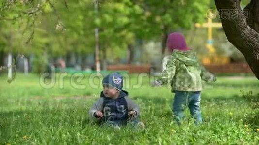 两个孩子在春天公园荡秋千视频