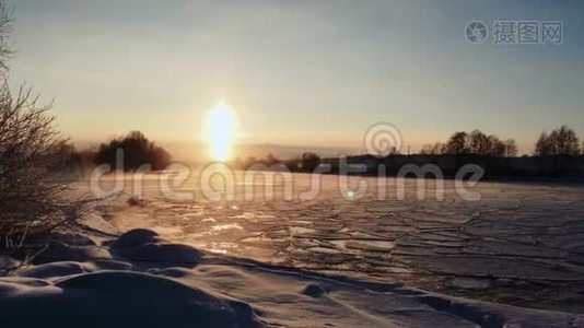 冰封的冰雪覆盖的河水上，冬日的霜落日视频