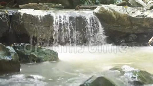 一个小瀑布和一条水流的岩石。视频