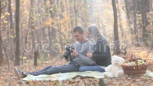 夫妻俩在镜头前看照片视频