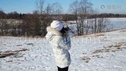 冬天公园里的女孩拿着相机拍照。视频