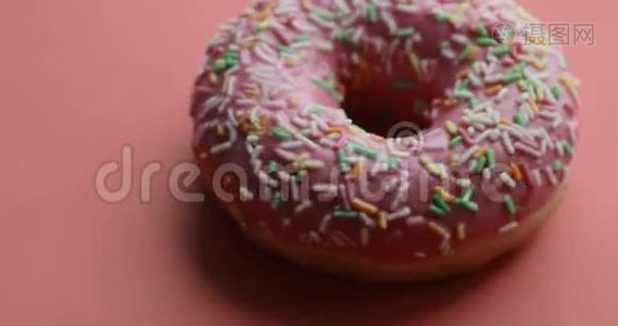 明亮而多彩的甜甜圈特写镜头旋转在红色背景上。 美味的甜甜甜面圈视频