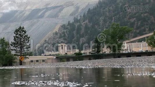 带有自然和建筑物的潮湿混凝土道路的低角度拍摄视频