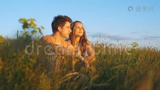 一对夫妇坐着看美丽的日落视频