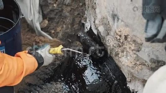 在黑色塑料管与混凝土之间的水泥针上涂上焦油视频