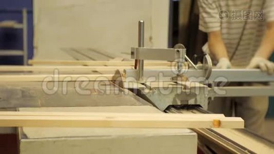 木工车间的工人在机器上锯木板视频