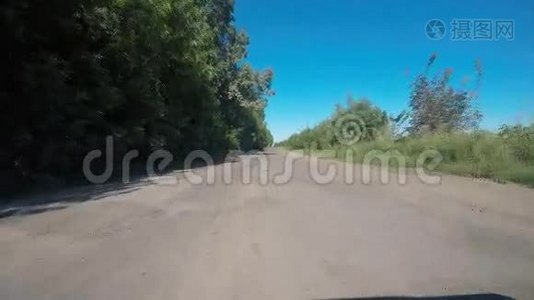 在乡村公路上驾驶汽车-POV-视角前方。 一辆汽车上的车载摄像机的录像片段视频