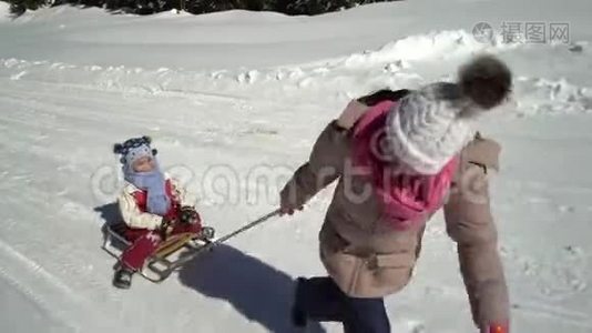 冬天，两个快乐美丽的孩子在雪山上玩着有趣的雪橇。 兄弟和兄弟视频