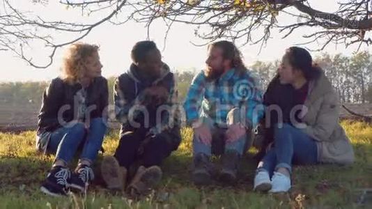 四个多种族的朋友坐在农村。视频