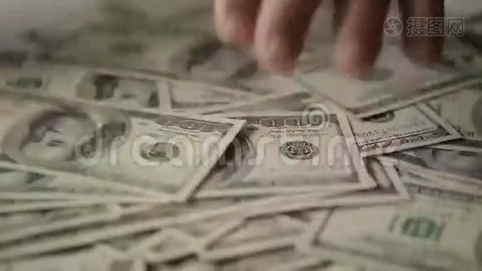 一个商人的手在桌子上数着一百美元的钞票视频