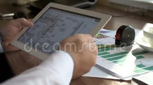 工程师使用平板电脑，同时工作与蓝图。视频