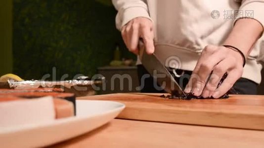 一个女孩的手特写在家厨房的一块木制砧板上小樱桃西红柿。家常菜视频