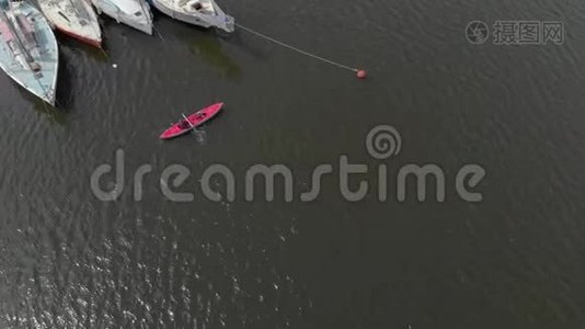 一个年轻人和他的儿子在海中或湖中的充气皮艇上划桨视频