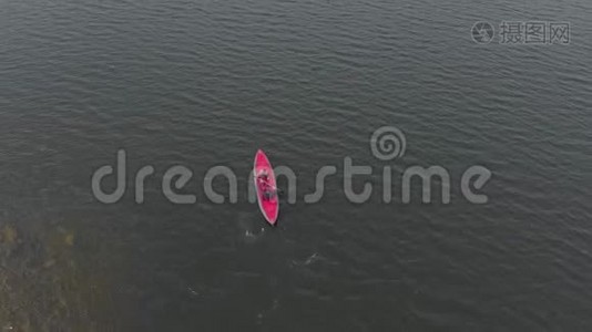 一个年轻人和他的儿子在海中或湖中的充气皮艇上划桨视频