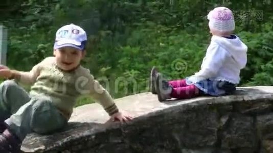 小可爱的男孩和女孩滑下石墙视频