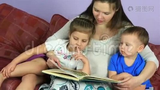 妈妈给他们的孩子们读一本书。 幸福的家庭在等第三个孩子。视频