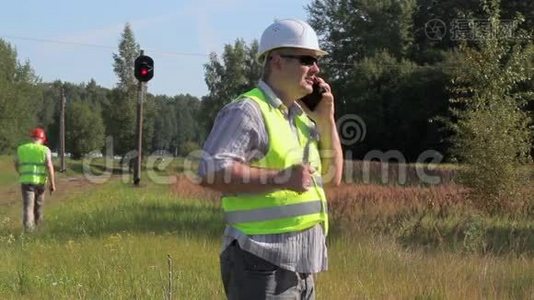 铁路工程师在铁路信号信标附近使用智能手机视频